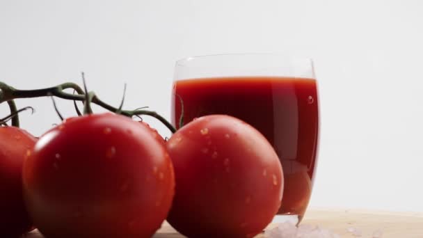Περιστρεφόμενο Ποτήρι Τοματοχυμό Και Ντομάτες Λευκό Φόντο Φρεσκοπαρασκευασμένος Χυμός Ντομάτας — Αρχείο Βίντεο