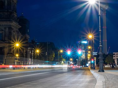 Berlin 'in gece caddelerinin manzarası ve arabaların bıraktığı ışık yolları. Gece Avrupa kenti.