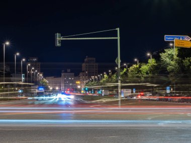 Berlin 'in gece caddelerinin manzarası ve arabaların bıraktığı ışık yolları. Gece Avrupa kenti.