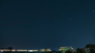 Gece yıldızlı gökyüzü şehrin üzerinde. Evlerin çatısının üstündeki yıldızlı gökyüzü.