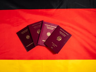 Almanya bayrağının arka planında bir Alman vatandaşının pasaportu. Alman vatandaşlığı edinme kavramı.