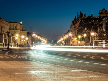 Berlin 'in gece caddelerinin manzarası ve arabaların bıraktığı ışık yolları. Gece Avrupa kenti.