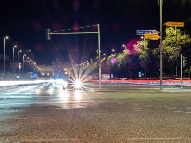 Berlin 'in gece caddelerinin manzarası ve arabaların bıraktığı ışık yolları. Gece Avrupa kenti.