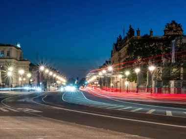Berlin 'in gece caddelerinin manzarası ve arabaların bıraktığı ışık yolları. Gece Avrupa kenti.