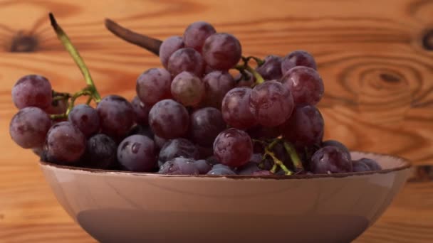 红葡萄在木制的背景上旋转 成熟的红葡萄 — 图库视频影像