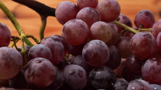 红葡萄在木制的背景上旋转 成熟的红葡萄 — 图库视频影像