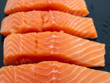 Slate Stone 'da somon balığı filetosu. Beyaz arka planda kırmızı balık filetosu..