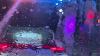 Bir konveyör tünelinin araba yıkama yerindeki arabanın içinden yakın çekim görüntüsü. Otomatik oto yıkamada araba yıkamak..