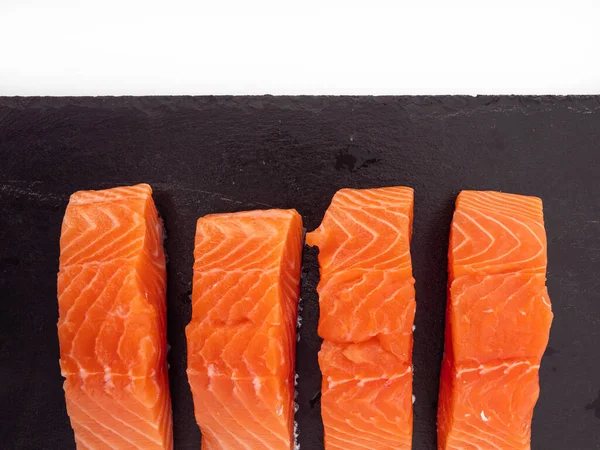 Salmon fish fillet on Slate stone. Red fish fillet close-up on a white background.