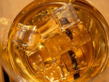 Tahta masadaki buzlu bir bardak viski. Buzlu viski, yakın plan.