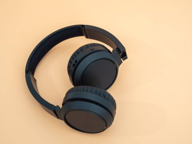 Turuncu arka planda siyah kablosuz kulaklık. Kablosuz kulaklıklar. Yakın plan..