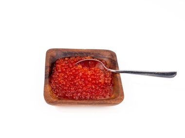 Beyaz arka planda kırmızı havyarlı tahta bardak. Kırmızı havyar yakın plan..