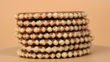 Turuncu arka planda dönen Belçika waffle 'ları. Taze Belçika waffle 'ları.