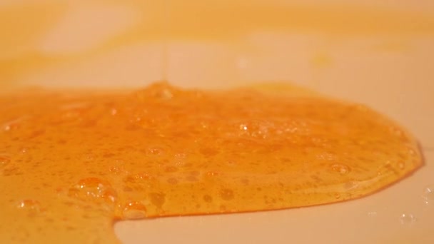 Liquid Shower Gel Flows Gracefully Bright Orange Background Translucent Waves — Stock Video