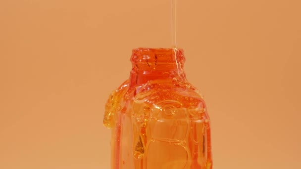 Flüssiges Duschgel Fließt Anmutig Einen Behälter Auf Orangefarbenem Hintergrund Das — Stockvideo