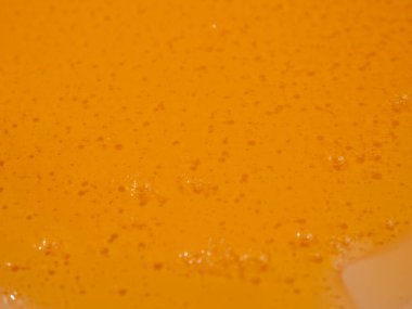 Sıvı duş jeli parlak turuncu bir arka planda zarifçe akar. Duş jelinin şeffaf dalgaları büyüleyici bir görsel senfoni yaratıyor. Sıvı duş jeli turuncu bir arka planda akar.