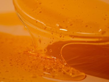 Sıvı duş jeli parlak turuncu bir arka planda zarifçe akar. Duş jelinin şeffaf dalgaları büyüleyici bir görsel senfoni yaratıyor. Sıvı duş jeli turuncu bir arka planda akar.