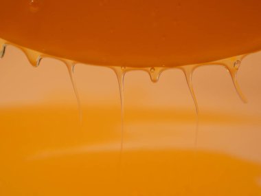 Sıvı duş jeli parlak turuncu bir arka planda zarifçe akar. Duş jelinin şeffaf dalgaları büyüleyici bir görsel senfoni yaratıyor. Sıvı duş jeli turuncu bir arka planda akar.