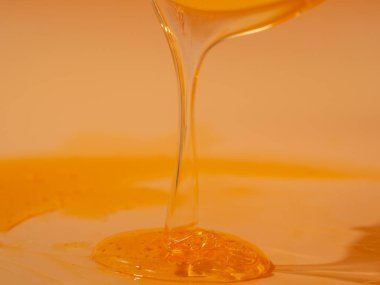 Sıvı duş jeli parlak turuncu bir arka planda zarifçe akar. Duş jelinin şeffaf dalgaları büyüleyici bir görsel senfoni yaratıyor. Sıvı duş jeli turuncu bir arka planda akar.