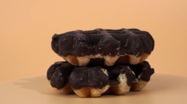 Turuncu arka planda dönen Belçika waffle 'ları. Taze Belçika waffle 'ları.