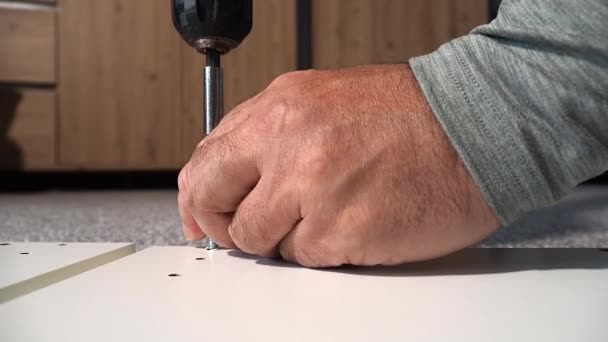 Een Master Monteert Meubels Met Behulp Van Een Elektrische Schroevendraaier — Stockvideo