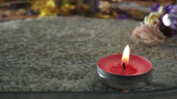 一支孤零零的点燃的蜡烛矗立在清澈的水面上 沙底和清水背景下的蜡烛 — 图库视频影像