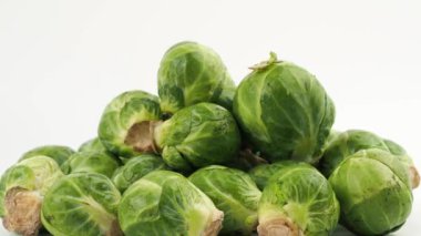 Brüksel lahanaları beyaz arka planda döner. Beyaz arka planda taze, küçük Brüksel lahanaları.