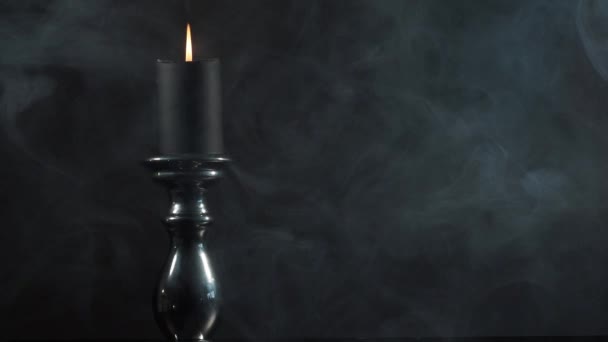 黑暗中的烛光 一支蜡烛 放在烛台上 在乌黑的背景下 笼罩在起起起云涌的浓烟中 — 图库视频影像
