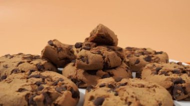 Yulaf ezmeli çikolatalı kurabiyeler turuncu arka planda döner. Çikolatalı klasik yulaf ezmeli kurabiyeler..