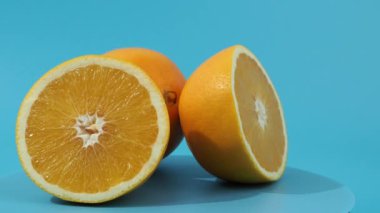 Olgun portakallar mavi arka planda döner. Mavi üzerine yakın plan portakallar.