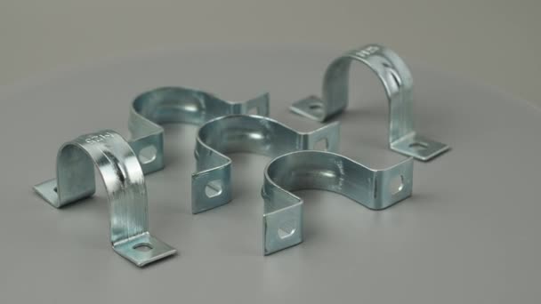 金属クランプは灰色の背景で回転します 薄い管を留めるための金属クランプ — ストック動画