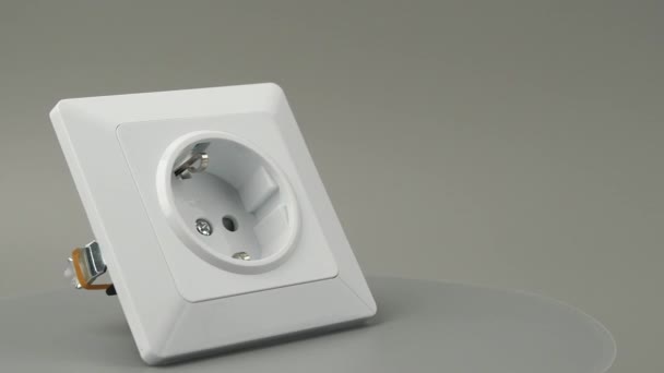 白色塑料电源插座在灰色背景上旋转 灰色背景的电源插座 — 图库视频影像