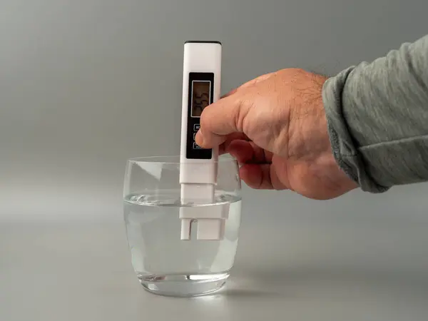 Water quality tester on a gray background. Device for measuring water quality.