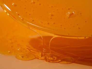 Sıvı duş jeli parlak turuncu bir arka planda zarifçe akar. Duş jelinin şeffaf dalgaları büyüleyici bir görsel senfoni yaratıyor. Sıvı duş jeli turuncu bir arka planda akar.