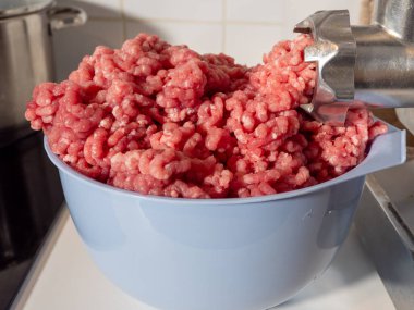 An electric meat grinder grinds meat into minced meat. Electric meat grinder close up clipart