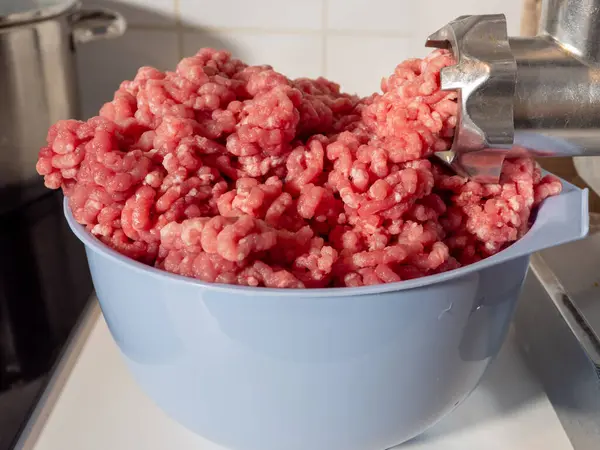 An electric meat grinder grinds meat into minced meat. Electric meat grinder close up