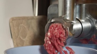 Elektrikli et öğütücüsü kullanarak eti öğütmek. Elektrikli et öğütücü eti kıyma haline getirir..