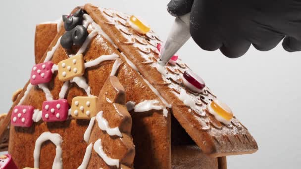 圣诞节姜饼的形状是一座房子 圣诞前用糖霜组装姜饼屋 — 图库视频影像