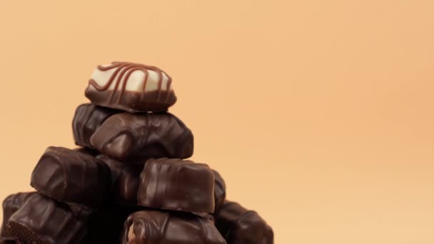 Los Caramelos Chocolate Giran Sobre Fondo Naranja Dulces Chocolate Cerca — Vídeo de stock