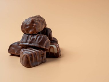 Turuncu arka planda çikolatalı şekerler. Çikolatalı şekerler yakın plan..