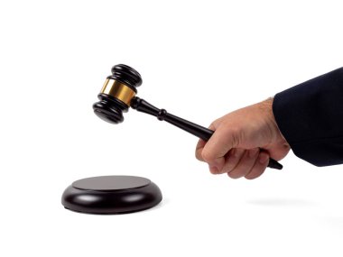 Beyaz bir arkaplanda izole edilmiş bir karar vermek için elinde tokmak olan bir yargıcın yakın çekim görüntüsü. Ahşap standı olan açık arttırma çekici. Hukuk ve adalet kavramı.
