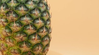 Olgun ananas turuncu bir arka planda döner. Ananas yakın plan..