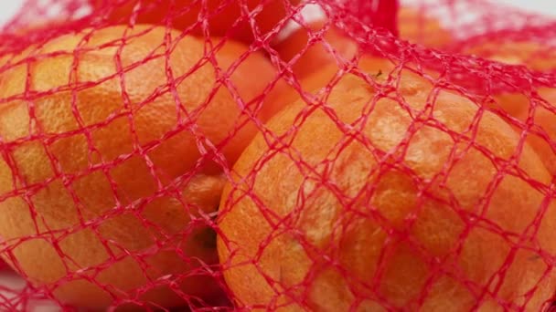 Eine Gruppe Tropischer Mandarinenfrüchte Einer Maschenverpackung Rotiert Auf Weißem Hintergrund — Stockvideo