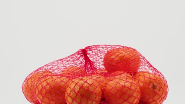 一组热带橘子果实在网状包裹中在白色背景上旋转 唐人街特写镜头 — 图库视频影像