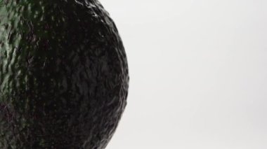 Avokado beyaz arka planda döner. Olgun avokado yakın çekim.