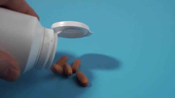 Tuang Keluar Obat Obatan Pil Dari Botol Plastik Permukaan Biru — Stok Video