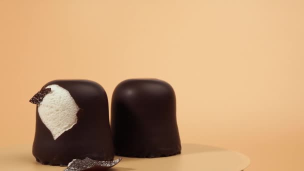 Los Malvaviscos Glaseado Chocolate Rotan Sobre Fondo Anaranjado Marshmallow Primer — Vídeos de Stock