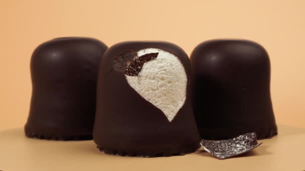 Marshmallow Dalam Coklat Glasir Berputar Pada Latar Belakang Oranye Marshmallow — Stok Video