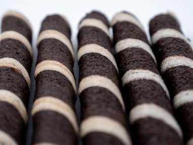 Beyaz arka planda gevrek waffle ruloları. Siyah ve beyaz gofret ruloları yakın çekim.