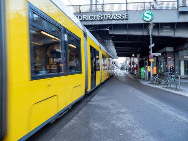 Berlin, Almanya, 10 Şubat 2024. Sarı bir tramvay tren istasyonunun yanındaki Friedrichstrasse boyunca ilerliyor. Berlin, Almanya, 10 Şubat 2024